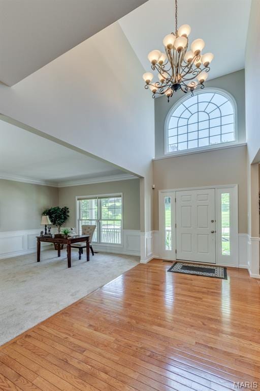 1515 Dietrich Glen Dr, Ballwin, MO 63021 - entrance foyer with a decorative wall, a towering ceiling, a chandelier, wood-type flooring, and a wainscoted wall