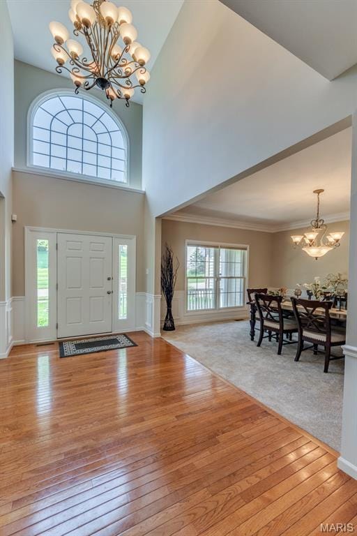 1515 Dietrich Glen Dr, Ballwin, MO 63021 - foyer featuring a chandelier, light wood-type flooring, a high ceiling, wainscoting, and ornamental molding