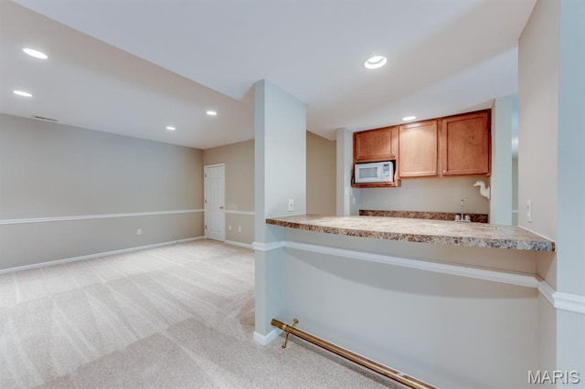 1515 Dietrich Glen Dr, Ballwin, MO 63021 - kitchen featuring white microwave, recessed lighting, light colored carpet, brown cabinets, and light countertops