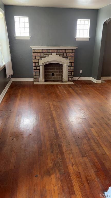 1178 Riverview Blvd, Saint Louis, MO 63147 - unfurnished living room with a fireplace, dark wood-style floors, and arched walkways