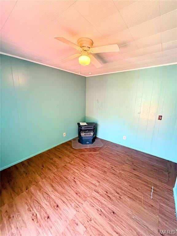169 Grand Ave, Lebanon, MO 65536 - unfurnished room featuring a wood stove, wood finished floors, and a ceiling fan