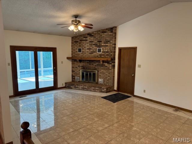 7 Forest Hills Dr, Washington, MO 63090 - unfurnished living room featuring lofted ceiling, a ceiling fan, light tile patterned flooring, a textured ceiling, and a fireplace