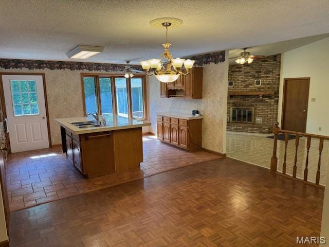 7 Forest Hills Dr, Washington, MO 63090 - kitchen featuring a ceiling fan, a textured ceiling, light countertops, a chandelier, and a kitchen island with sink