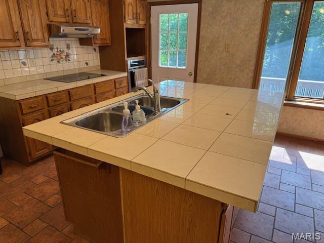7 Forest Hills Dr, Washington, MO 63090 - kitchen with under cabinet range hood, black electric cooktop, oven, stone tile floors, and wallpapered walls