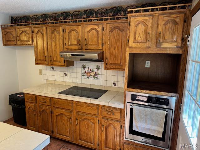7 Forest Hills Dr, Washington, MO 63090 - kitchen featuring oven, black electric stovetop, tile countertops, and under cabinet range hood