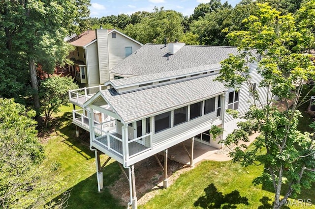 510 Wetherby Terrace Dr, Ballwin, MO 63021 - rear view of house featuring roof with shingles, a chimney, a lawn, and a wooden deck