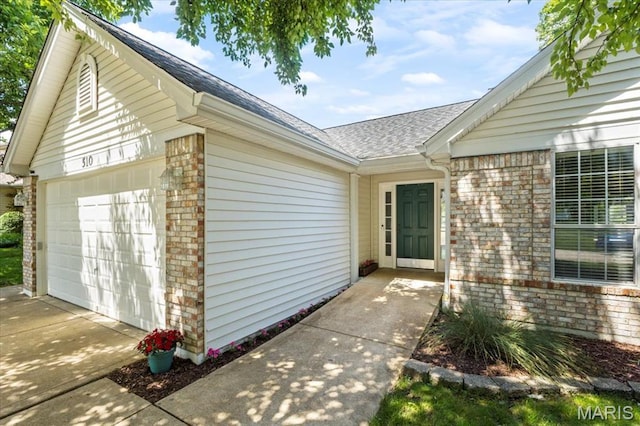 510 Wetherby Terrace Dr, Ballwin, MO 63021 - property entrance with roof with shingles, driveway, a garage, and brick siding