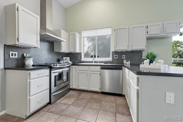 510 Wetherby Terrace Dr, Ballwin, MO 63021 - kitchen featuring appliances with stainless steel finishes, wall chimney range hood, dark countertops, decorative backsplash, and a towering ceiling