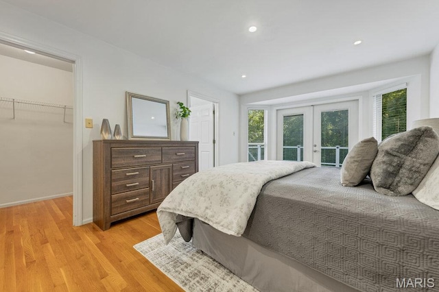 510 Wetherby Terrace Dr, Ballwin, MO 63021 - bedroom featuring french doors, light wood-type flooring, a walk in closet, access to exterior, and recessed lighting