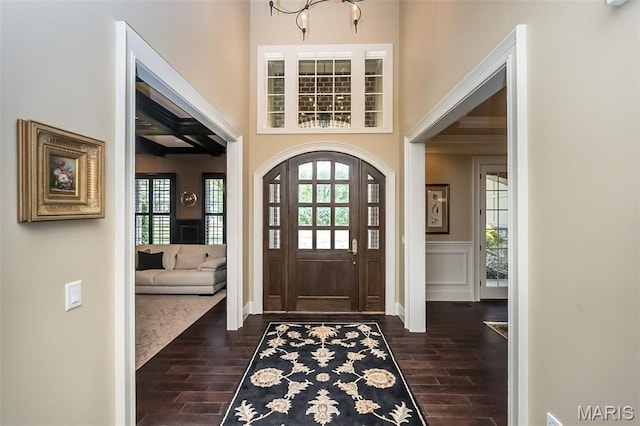 21 Lynnbrook Rd, Saint Louis, MO 63131 - entrance foyer featuring dark wood-style floors, wainscoting, a chandelier, ornamental molding, and a decorative wall