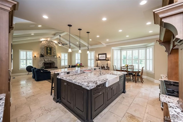 21 Lynnbrook Rd, Saint Louis, MO 63131 - kitchen with a stone fireplace, stone tile flooring, open floor plan, a breakfast bar, and crown molding