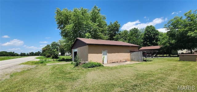 8739 Shawneetown Trl, Chester, IL 62233 - view of side of home featuring concrete block siding, a yard, and an outbuilding