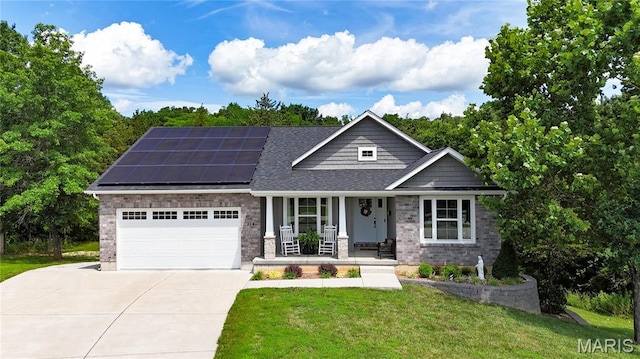 358 N Thomas St, De Soto, MO 63020 - view of front facade with covered porch, driveway, roof mounted solar panels, a front lawn, and an attached garage
