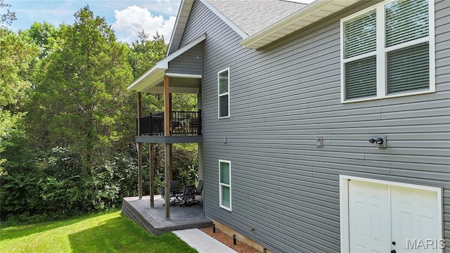 358 N Thomas St, De Soto, MO 63020 - view of side of property with a yard, a patio, a shingled roof, and a balcony