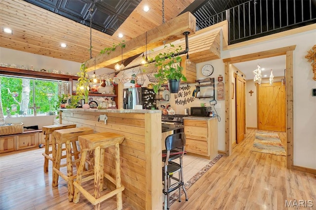 3204 Westwood Rd, Saint Clair, MO 63077 - kitchen with stainless steel fridge, light wood-style flooring, recessed lighting, a kitchen bar, and hanging light fixtures