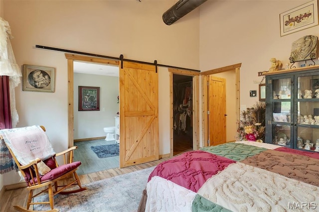 3204 Westwood Rd, Saint Clair, MO 63077 - bedroom with a barn door, wood finished floors, a spacious closet, a towering ceiling, and ensuite bath