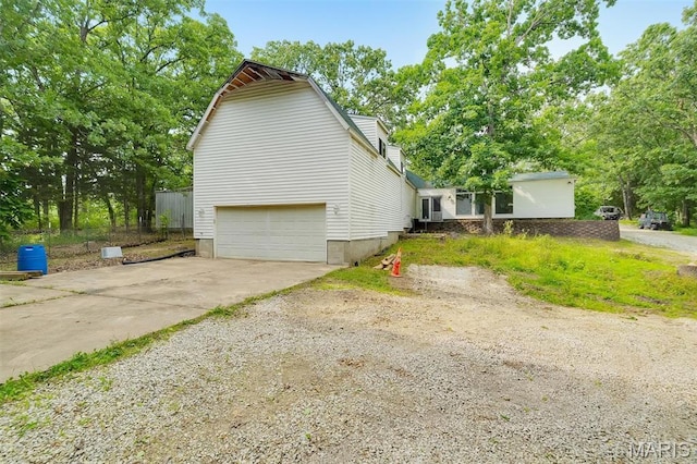 3080 Westwood Rd, Saint Clair, MO 63077 - view of side of home featuring a garage, concrete driveway, and view of wooded area