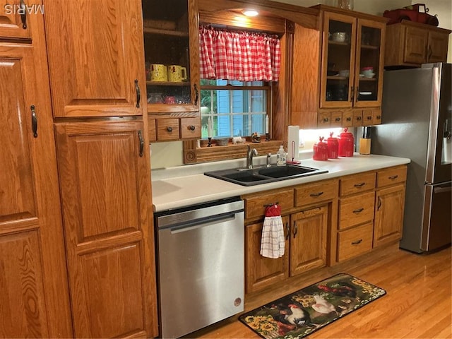11996 County Road 3290, Rolla, MO 65401 - kitchen with appliances with stainless steel finishes, brown cabinetry, glass insert cabinets, light countertops, and light wood finished floors