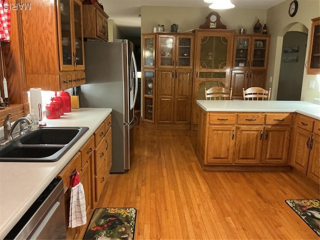 11996 County Road 3290, Rolla, MO 65401 - kitchen with appliances with stainless steel finishes, brown cabinetry, arched walkways, light countertops, and light wood-style flooring