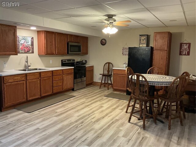 11996 County Road 3290, Rolla, MO 65401 - kitchen featuring stainless steel appliances, a drop ceiling, brown cabinetry, light wood finished floors, and a ceiling fan