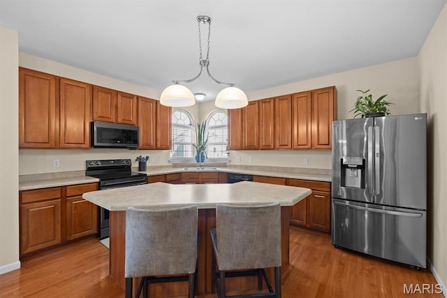 6817 Dunhill Dr, Fairview Heights, IL 62208 - kitchen featuring stainless steel appliances, light countertops, wood finished floors, and brown cabinetry