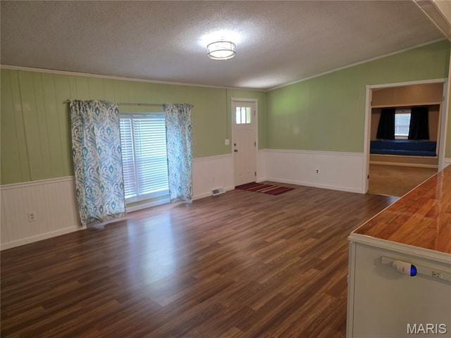 402 Il Route 143, Pocahontas, IL 62275 - unfurnished living room with a textured ceiling, ornamental molding, a wainscoted wall, and dark wood-style floors