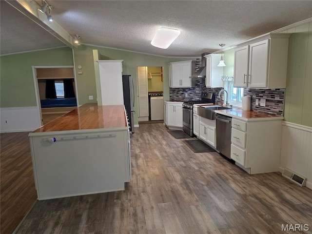 402 Il Route 143, Pocahontas, IL 62275 - kitchen featuring appliances with stainless steel finishes, wall chimney exhaust hood, dark wood-type flooring, white cabinetry, and vaulted ceiling