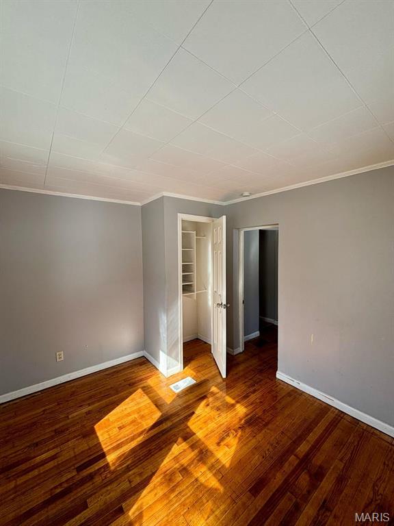 10109 Imperial Dr, Saint Louis, MO 63136 - unfurnished bedroom with crown molding, wood finished floors, a closet, and a spacious closet