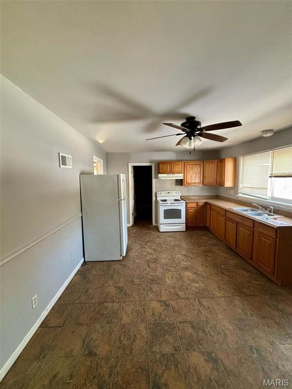 10109 Imperial Dr, Saint Louis, MO 63136 - kitchen featuring white appliances, under cabinet range hood, ceiling fan, brown cabinets, and light countertops