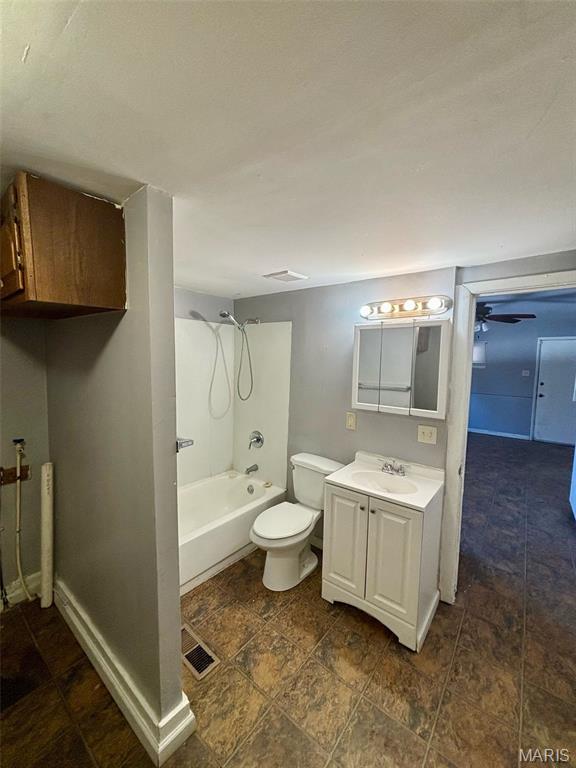 10109 Imperial Dr, Saint Louis, MO 63136 - bathroom with vanity, washtub / shower combination, a ceiling fan, and stone finish flooring