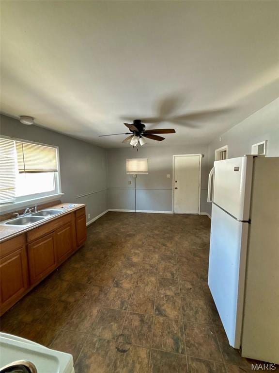 10109 Imperial Dr, Saint Louis, MO 63136 - kitchen featuring freestanding refrigerator, ceiling fan, brown cabinets, and light countertops
