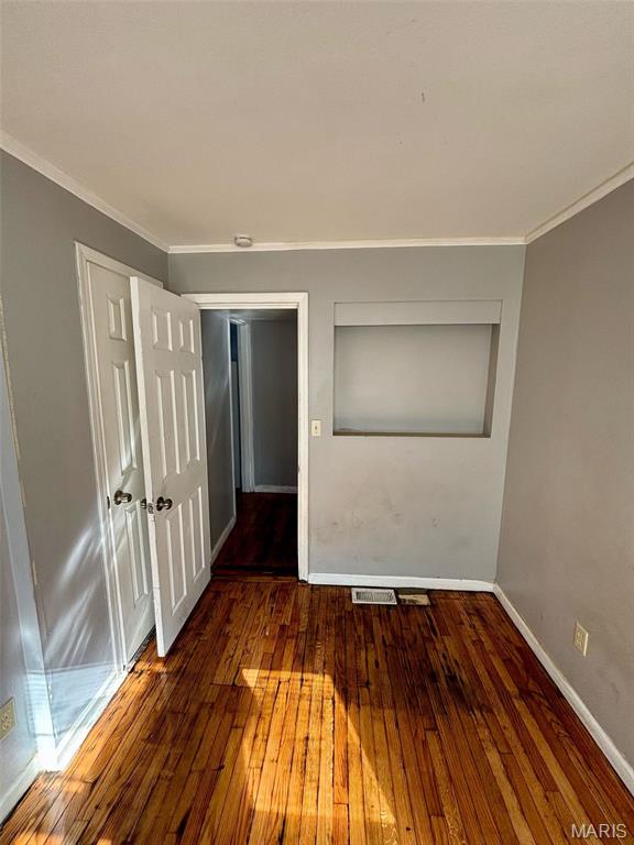 10109 Imperial Dr, Saint Louis, MO 63136 - unfurnished room with hardwood / wood-style flooring, ornamental molding, and a smoke detector