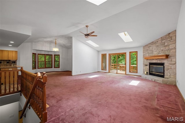 976 Aspenetter Dr, Innsbrook, MO 63390 - unfurnished living room with vaulted ceiling, a skylight, carpet floors, a stone fireplace, and ceiling fan