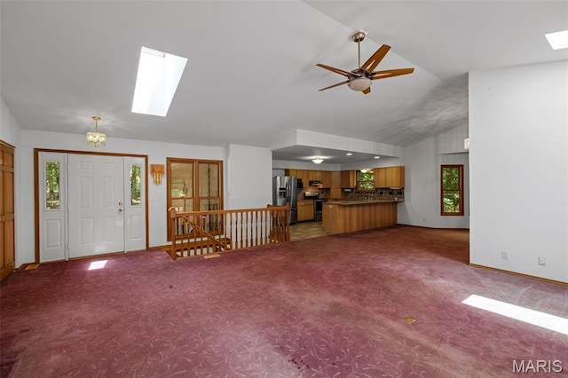 976 Aspenetter Dr, Innsbrook, MO 63390 - unfurnished living room featuring a skylight, vaulted ceiling, carpet floors, and plenty of natural light