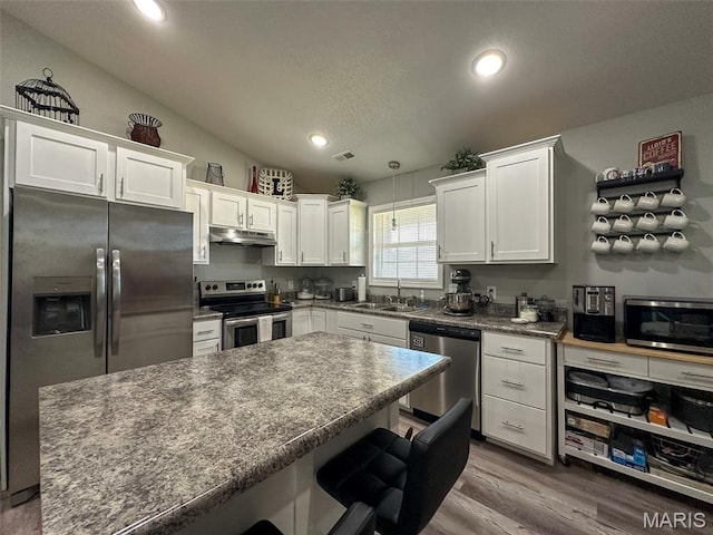 326 Apple Park Way, Poplar Bluff, MO 63901 - kitchen with stainless steel appliances, under cabinet range hood, white cabinets, a breakfast bar area, and recessed lighting