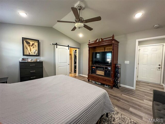 326 Apple Park Way, Poplar Bluff, MO 63901 - bedroom with a barn door, vaulted ceiling, wood finished floors, a spacious closet, and a ceiling fan