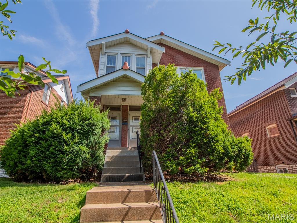 4945 Sutherland Ave, Saint Louis, MO 63109 - view of front of property with brick siding, a front lawn, and covered porch