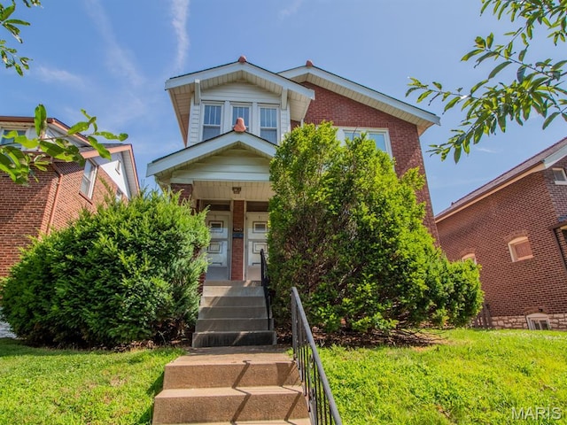 4945 Sutherland Ave, Saint Louis, MO 63109 - view of front of property with brick siding, a front lawn, and covered porch