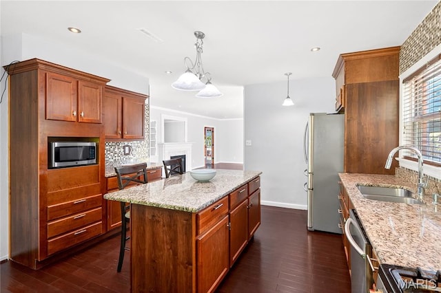 351 N 66th St, Belleville, IL 62223 - kitchen with appliances with stainless steel finishes, dark wood-style flooring, light stone counters, a kitchen island, and tasteful backsplash
