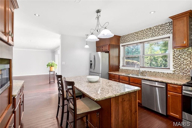 351 N 66th St, Belleville, IL 62223 - kitchen with appliances with stainless steel finishes, light stone counters, a breakfast bar area, dark wood-type flooring, and a center island