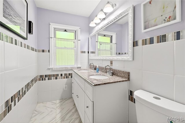 351 N 66th St, Belleville, IL 62223 - bathroom featuring tile walls, double vanity, wainscoting, and marble finish flooring