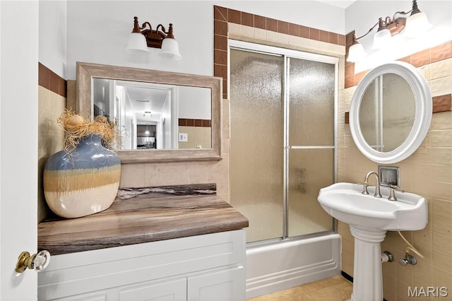 351 N 66th St, Belleville, IL 62223 - bathroom with tile walls, shower / bath combination with glass door, tasteful backsplash, and tile patterned flooring