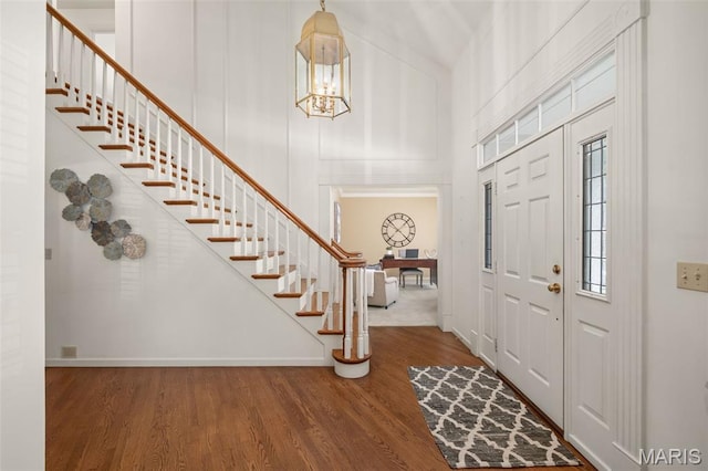649 Westledge Ct, Des Peres, MO 63131 - foyer featuring stairs, a towering ceiling, wood finished floors, and a chandelier