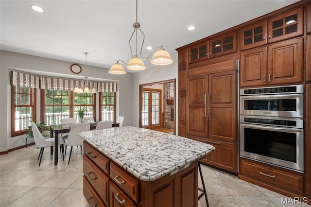 649 Westledge Ct, Des Peres, MO 63131 - kitchen featuring double oven, paneled built in refrigerator, a kitchen island, recessed lighting, and light stone counters