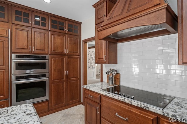 649 Westledge Ct, Des Peres, MO 63131 - kitchen featuring premium range hood, black electric cooktop, stainless steel double oven, backsplash, and light stone counters