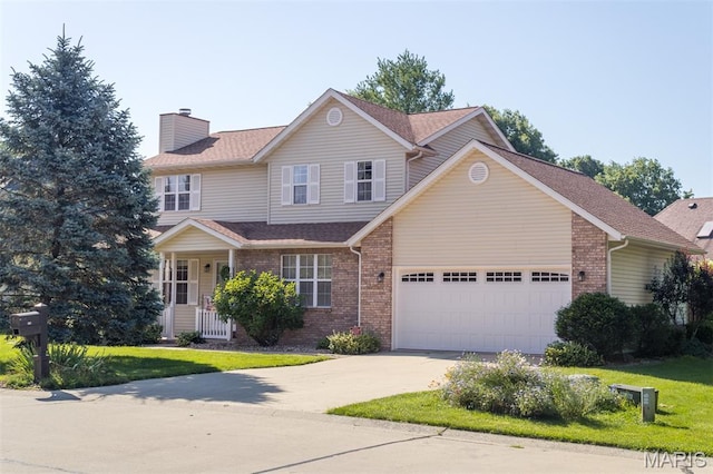 170 Coventry Way, Highland, IL 62249 - traditional-style house with a chimney, driveway, an attached garage, brick siding, and a front yard