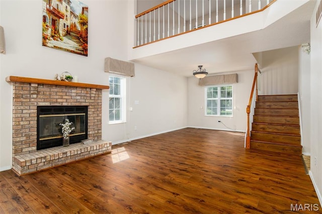 170 Coventry Way, Highland, IL 62249 - unfurnished living room featuring hardwood / wood-style flooring, stairway, a fireplace, and a towering ceiling