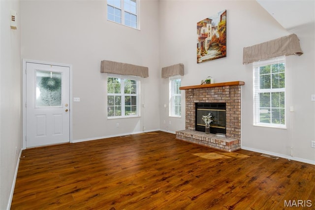 170 Coventry Way, Highland, IL 62249 - unfurnished living room with a towering ceiling, hardwood / wood-style floors, plenty of natural light, and a fireplace