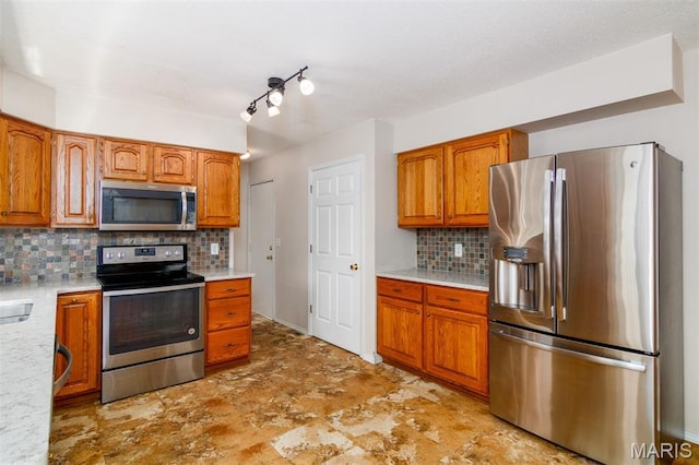 170 Coventry Way, Highland, IL 62249 - kitchen with appliances with stainless steel finishes, brown cabinets, light countertops, and decorative backsplash