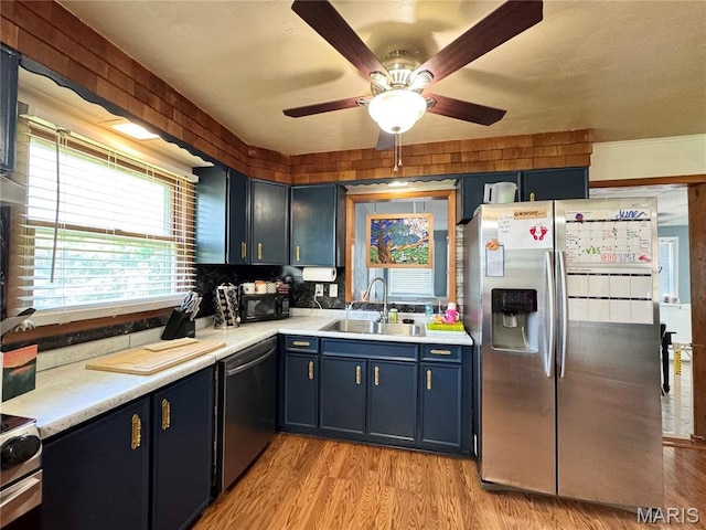 56319 Meyer Trl, Hannibal, MO 63401 - kitchen featuring appliances with stainless steel finishes, light countertops, light wood-style floors, ceiling fan, and blue cabinetry